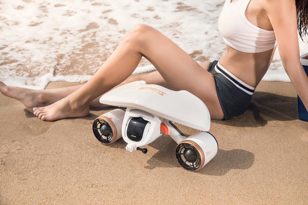 fille mannequin prend la pose sur le sable avec un scooter sous marin sublue