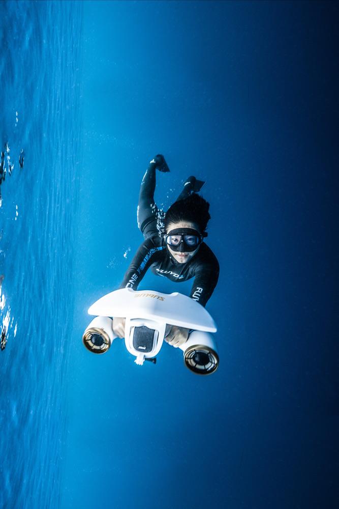 nageuse dans une mer bleu avec un scooter sous marin sublue mix pro