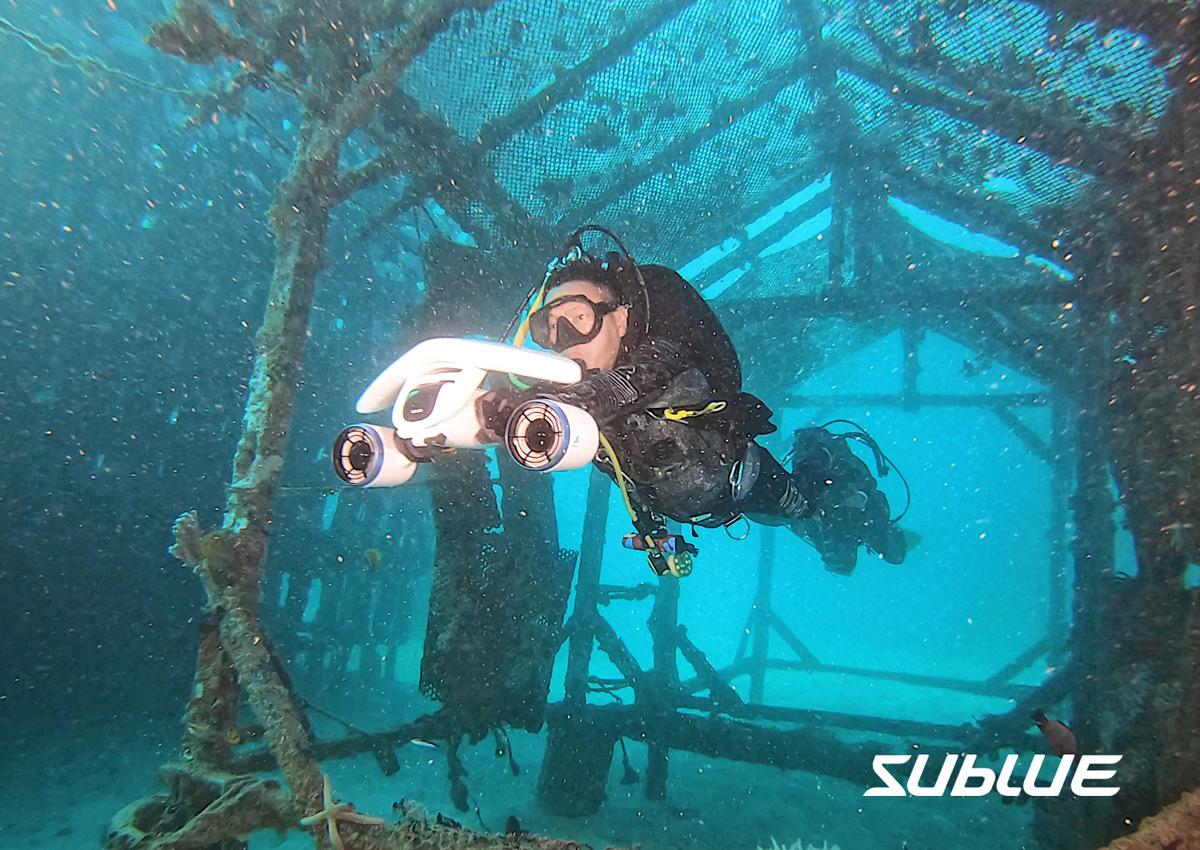 plongeur qui visite une épave en scooter sous marin
