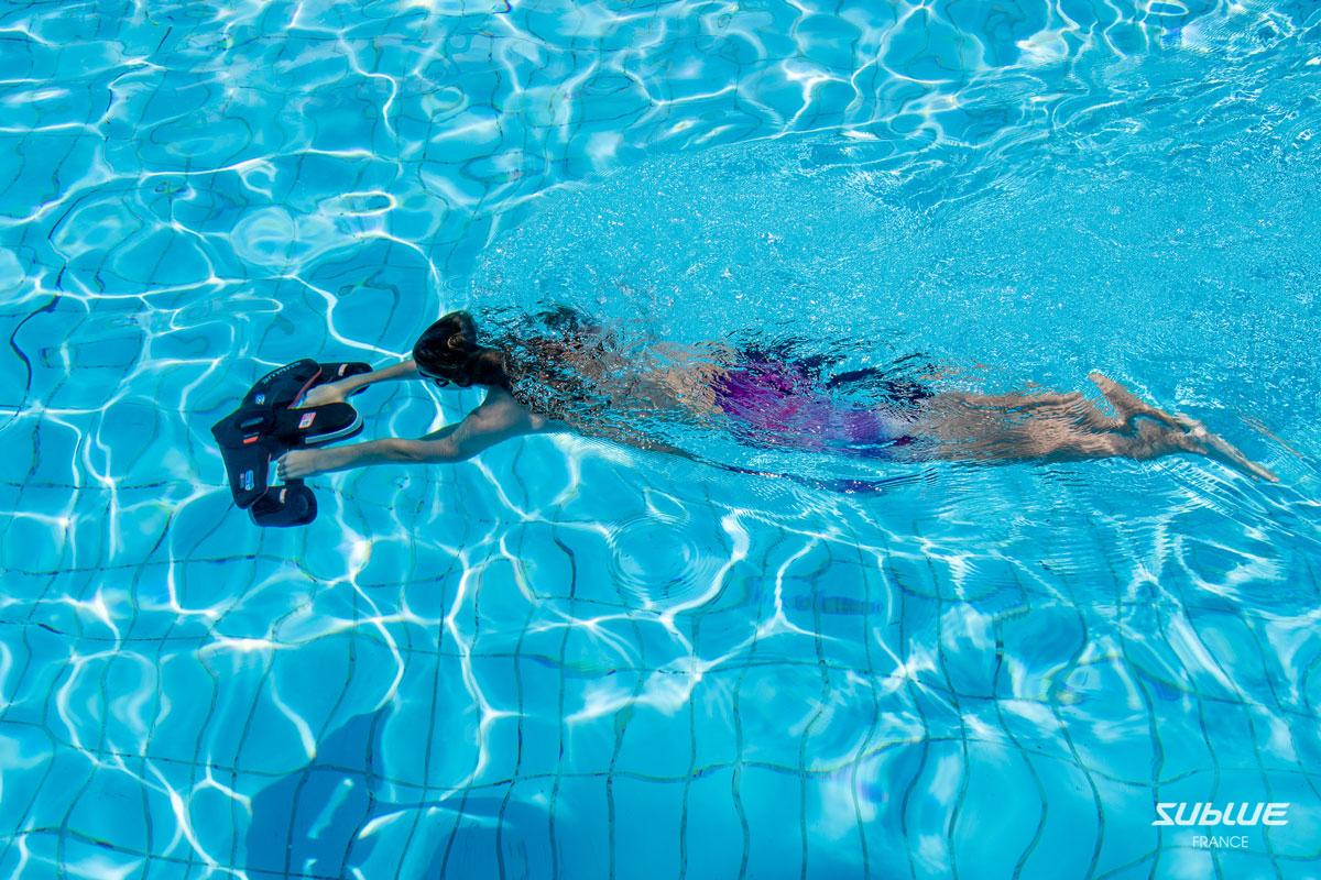 nageur en apnée dans une piscine avec un scooter sous marin