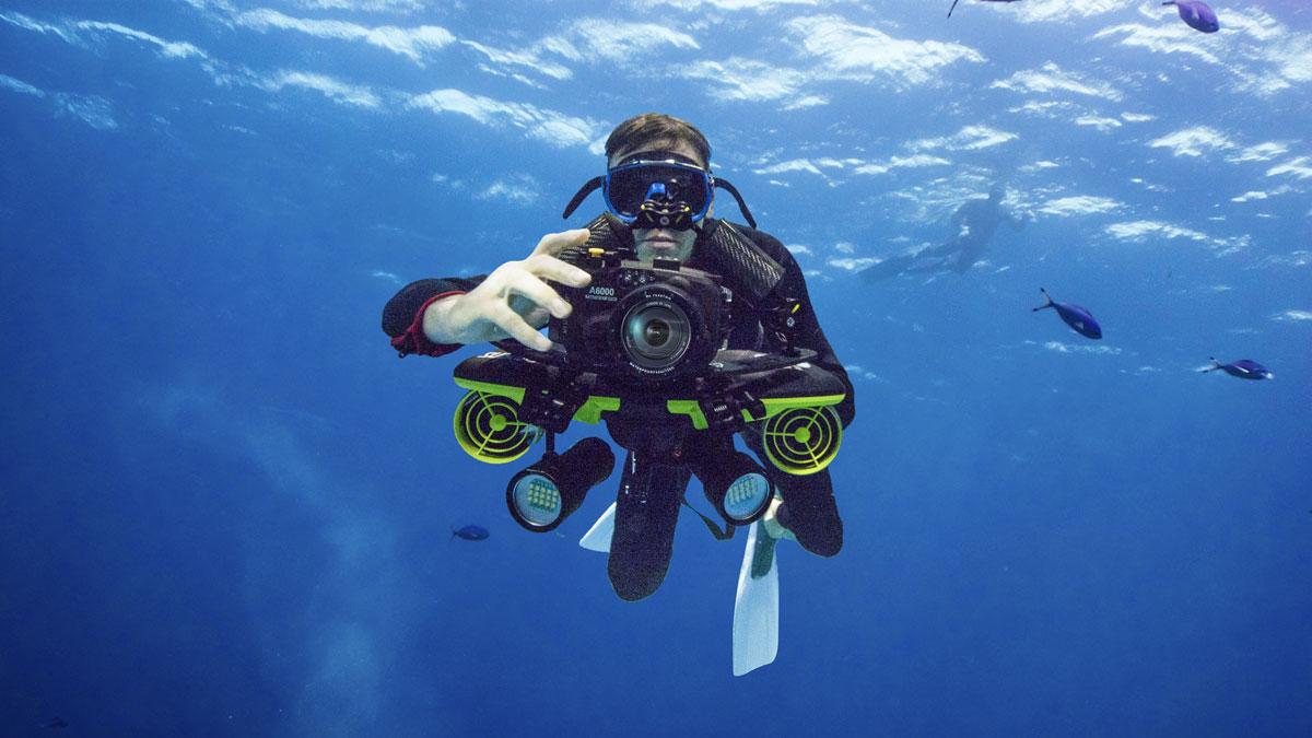 photographe professionnel avec un scooter sous marin sublue sous l'eau