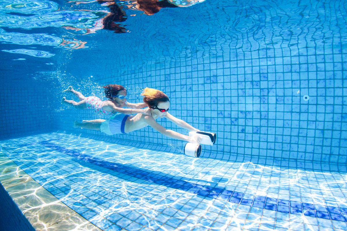 enfants qui jouent dans une piscine avec un scooter sous marin sublue qui les tracte