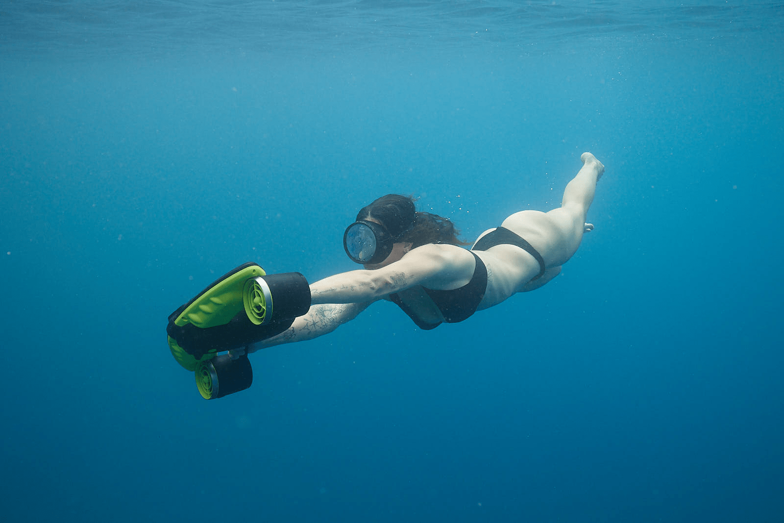 femme avec un scooter sous marin vert de sublue en Plongée