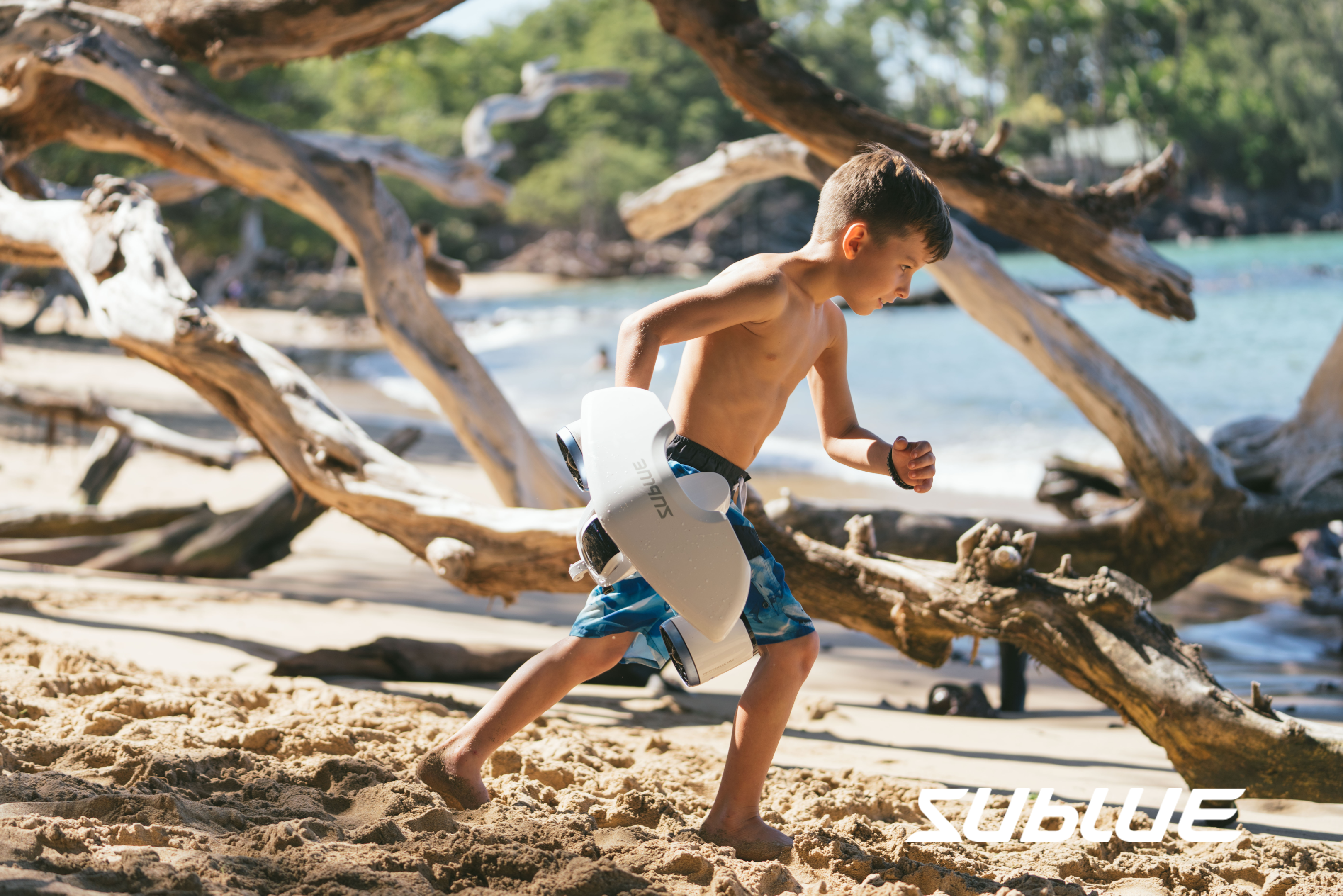 enfant qui cours sur la plage avec le scooter sous marin whiteshark mix de sublue