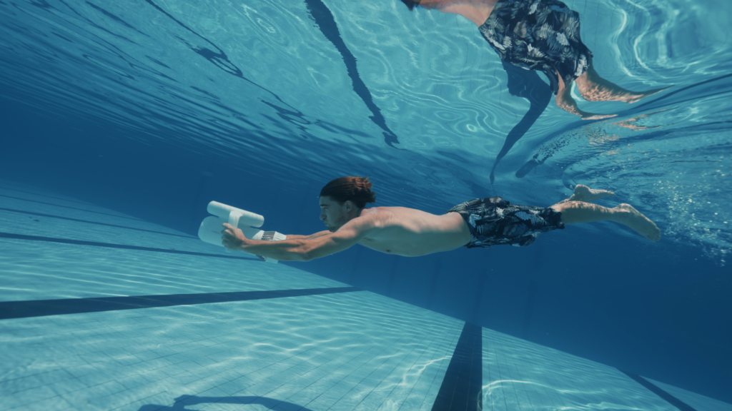 homme sous l'eau en piscine avec un scooter sous marin