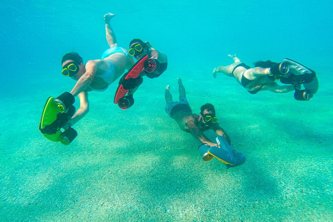 groupe avec scooter sous marin sous l'eau