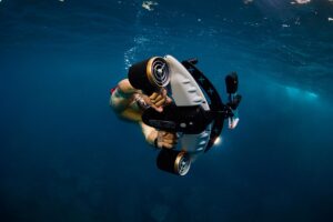 Plongeur utilisant un scooter sous-marin Sublue sous l'eau en mer bleue