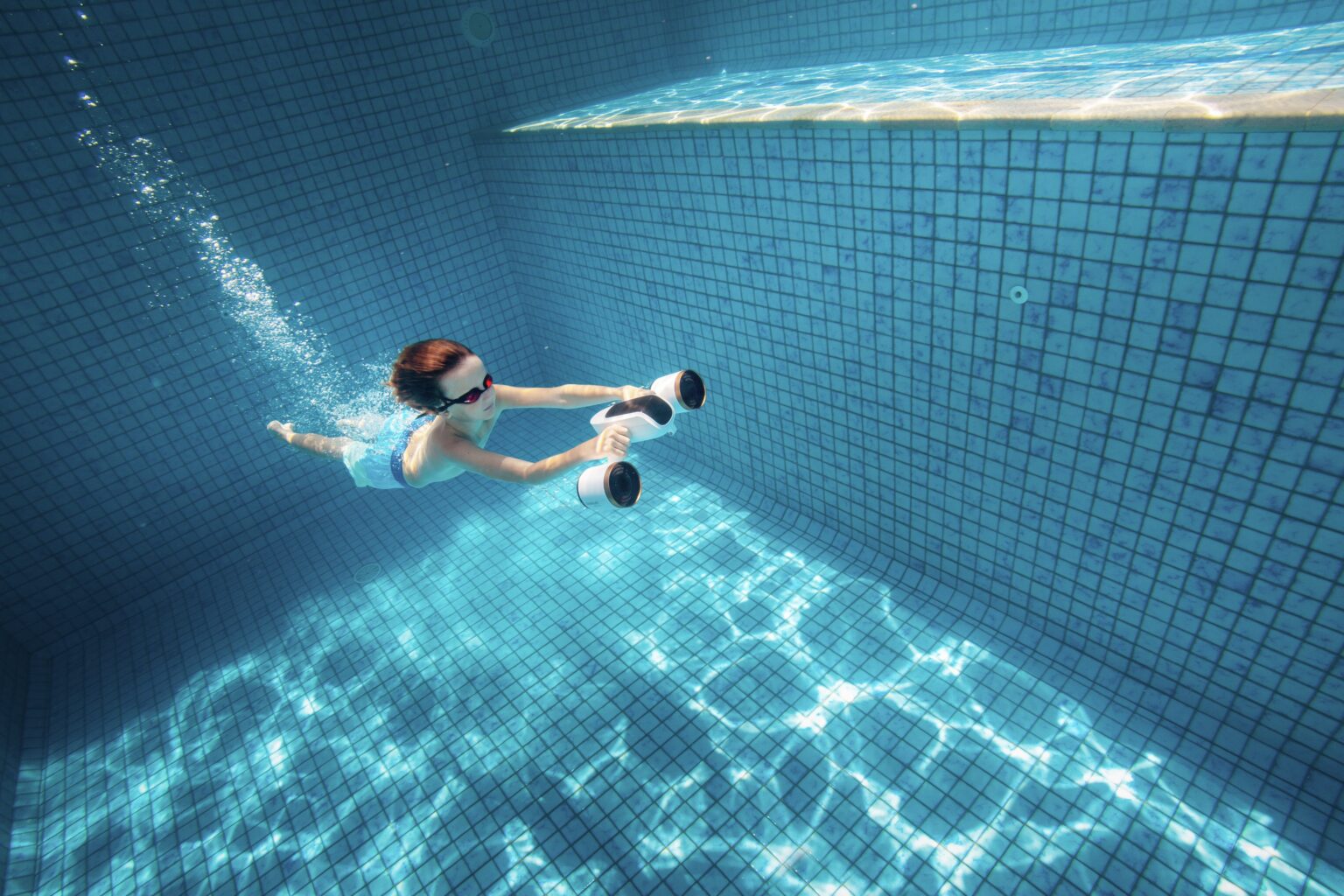 Criança numa piscina com um scooter subaquático Sublue Mix Pro