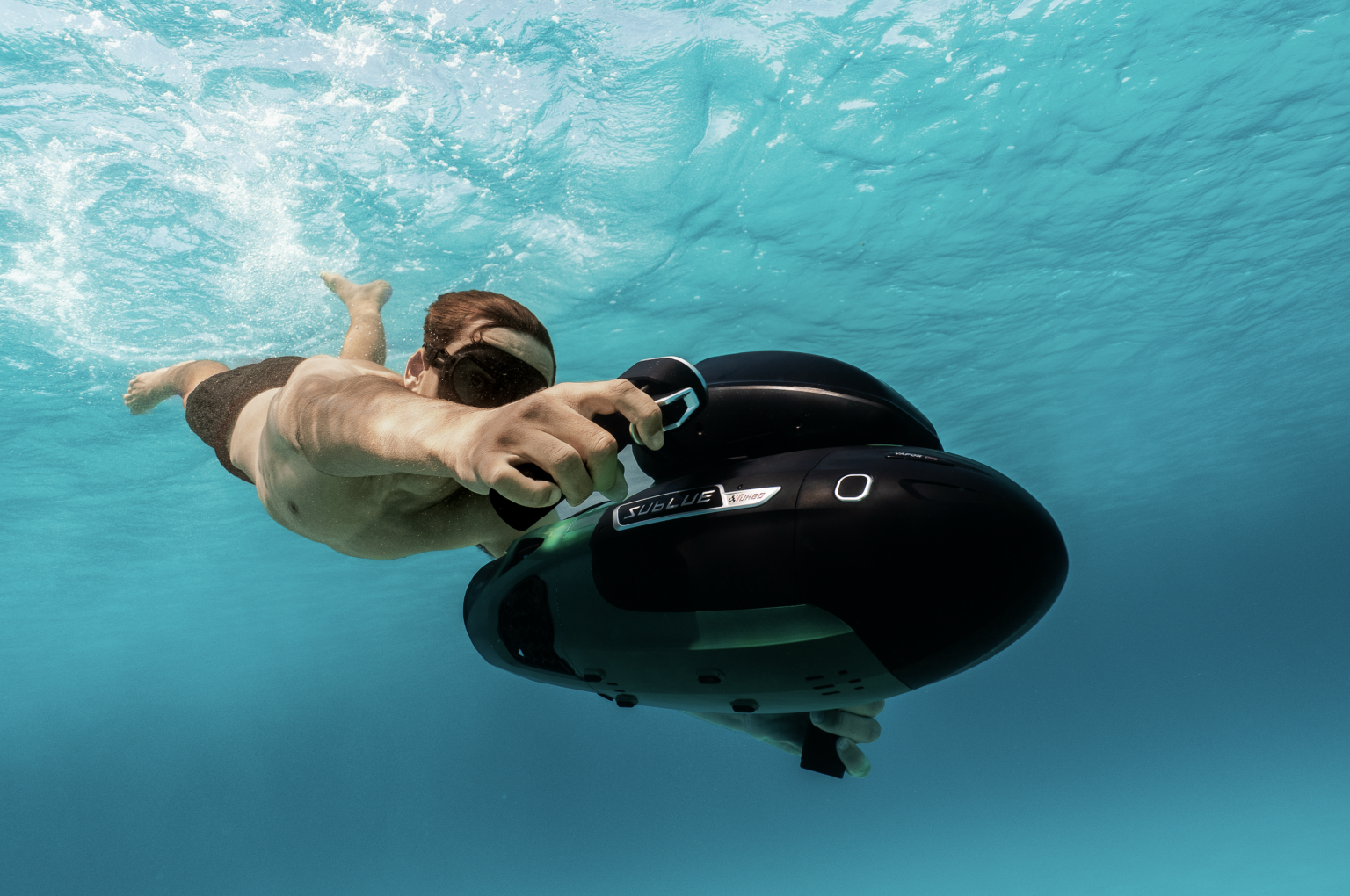 Swimmer in turquoise water with a Sublue Vapor Pro underwater scooter
